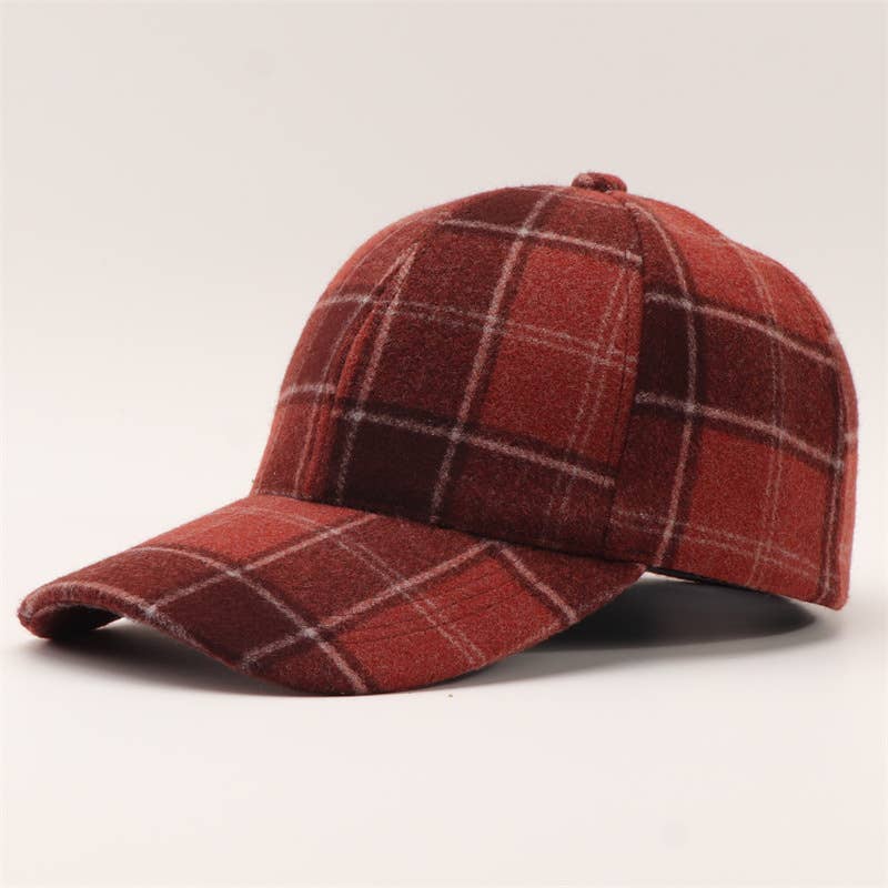 A red and brown plaid wool cap with a curved brim, photographed on a clean off-white background.