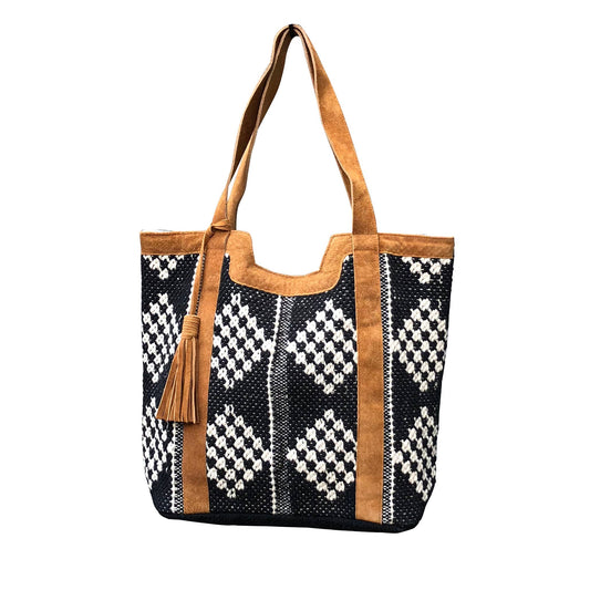 Tote bag with black and white pattern and brown handles on a white background