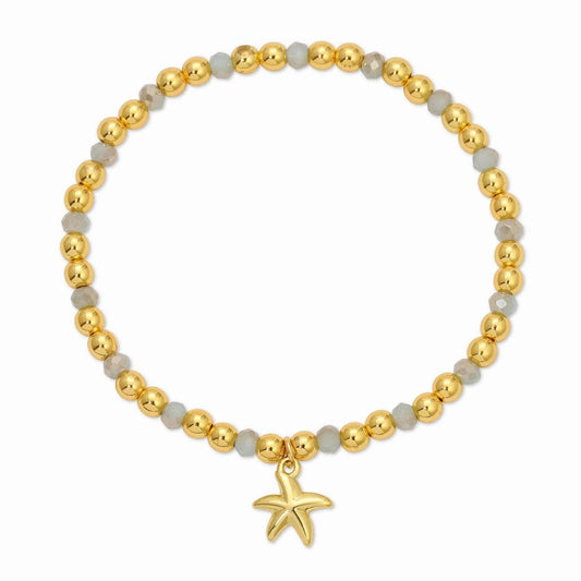 Bracelet with gold beads and a starfish charm on a white background