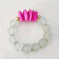 Bracelet with white beads and pink and gold accents on a light gray background
