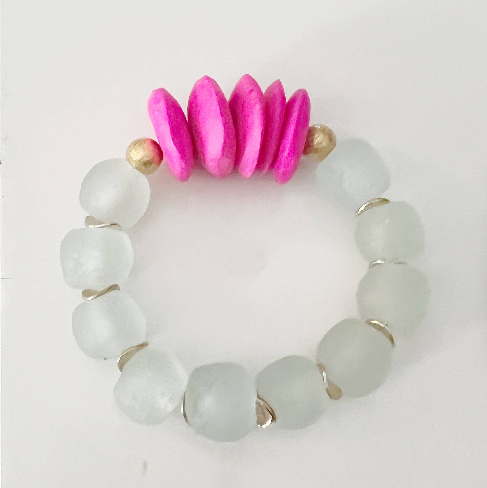 Bracelet with white beads and pink and gold accents on a light gray background