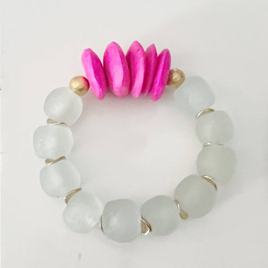 Bracelet with white beads and pink and gold accents on a light gray background
