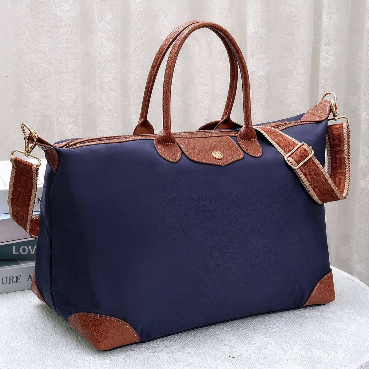 Navy blue handbag with brown leather accents on a light background