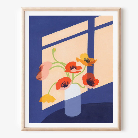 Framed artwork of flowers in a vase against a blue and beige background