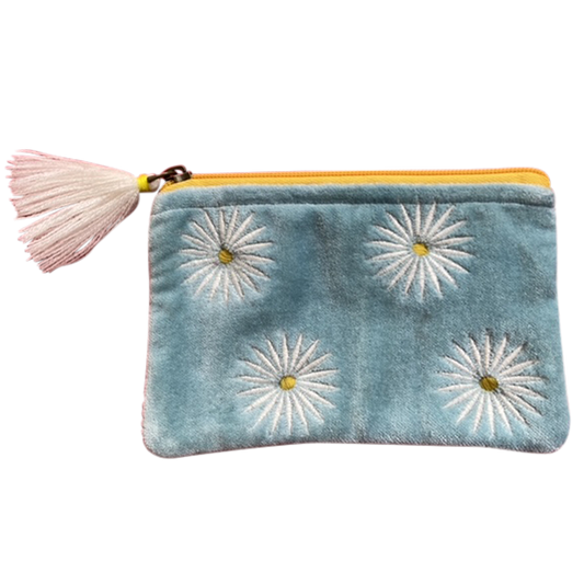Blue pouch with white floral designs and a pink tassel on a white background