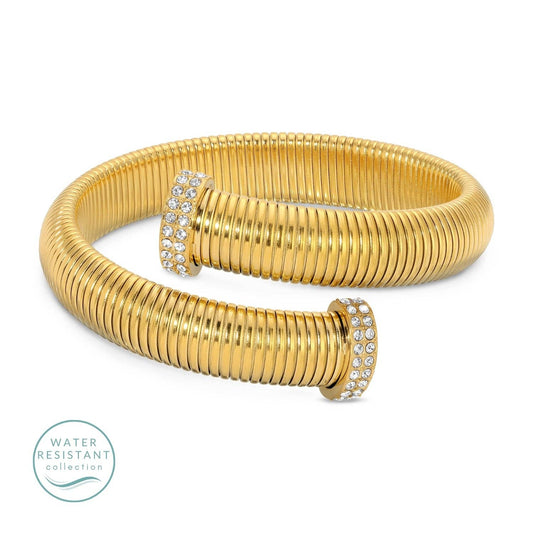 Gold bracelet with ribbed design and diamond accents on a black background