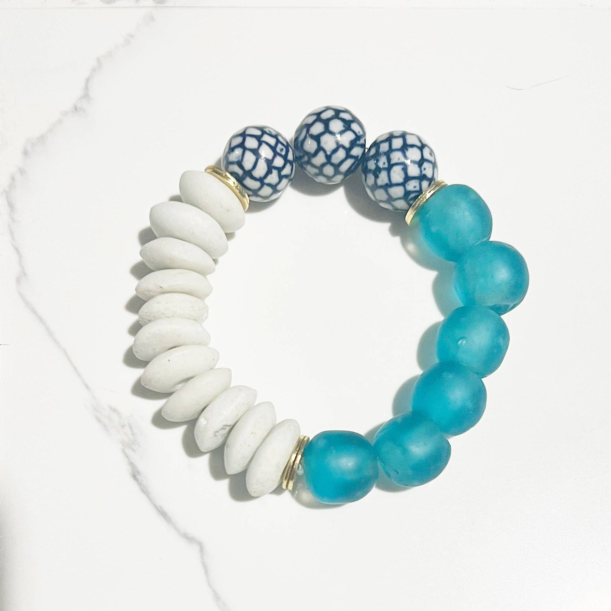 Bracelet with white, blue, and patterned beads on a white background