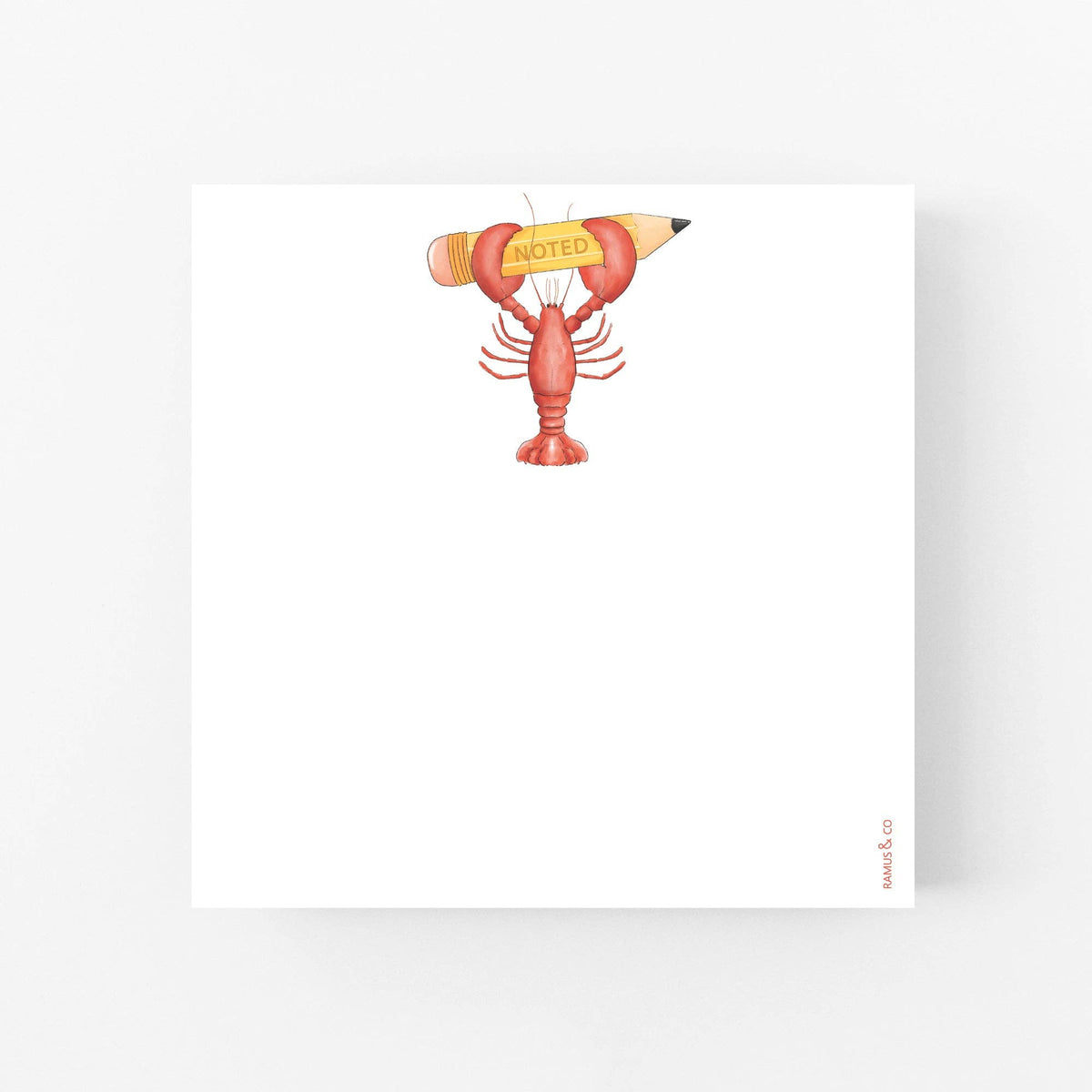 A square white notepad or card with a small illustration near the top center of a lobster holding a yellow pencil labeled 'NOTED'. The notepad is photographed on a clean white background with a soft shadow.