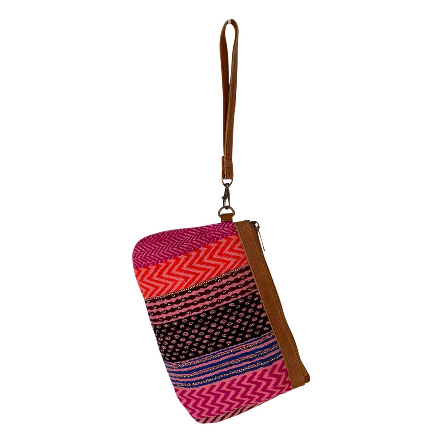 A small wristlet clutch with a brown leather strap and trim, featuring a vibrant multicolor patterned fabric body with pink, red, orange, and black zigzag and dotted stripes.