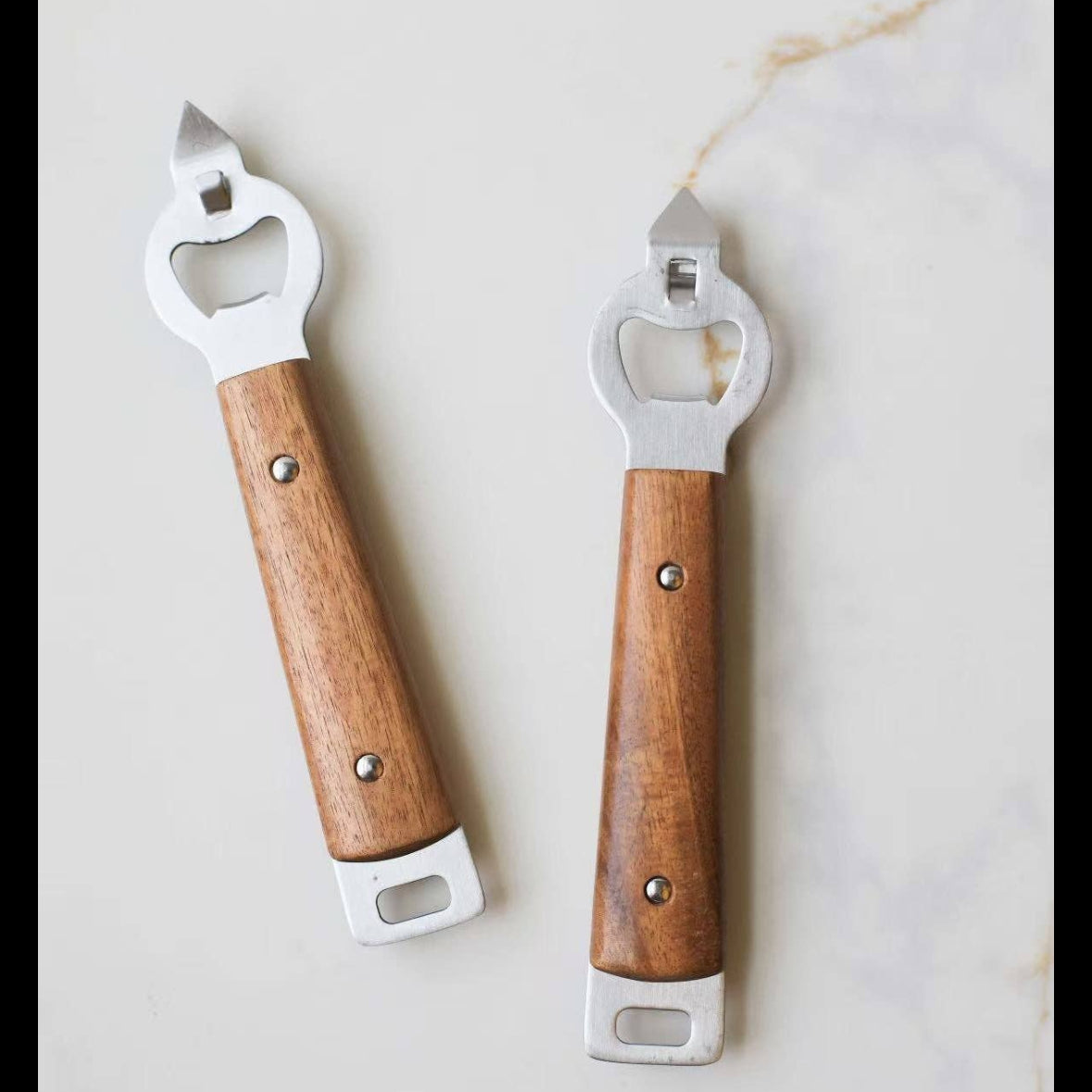 Two bottle openers with wooden handles on a light background