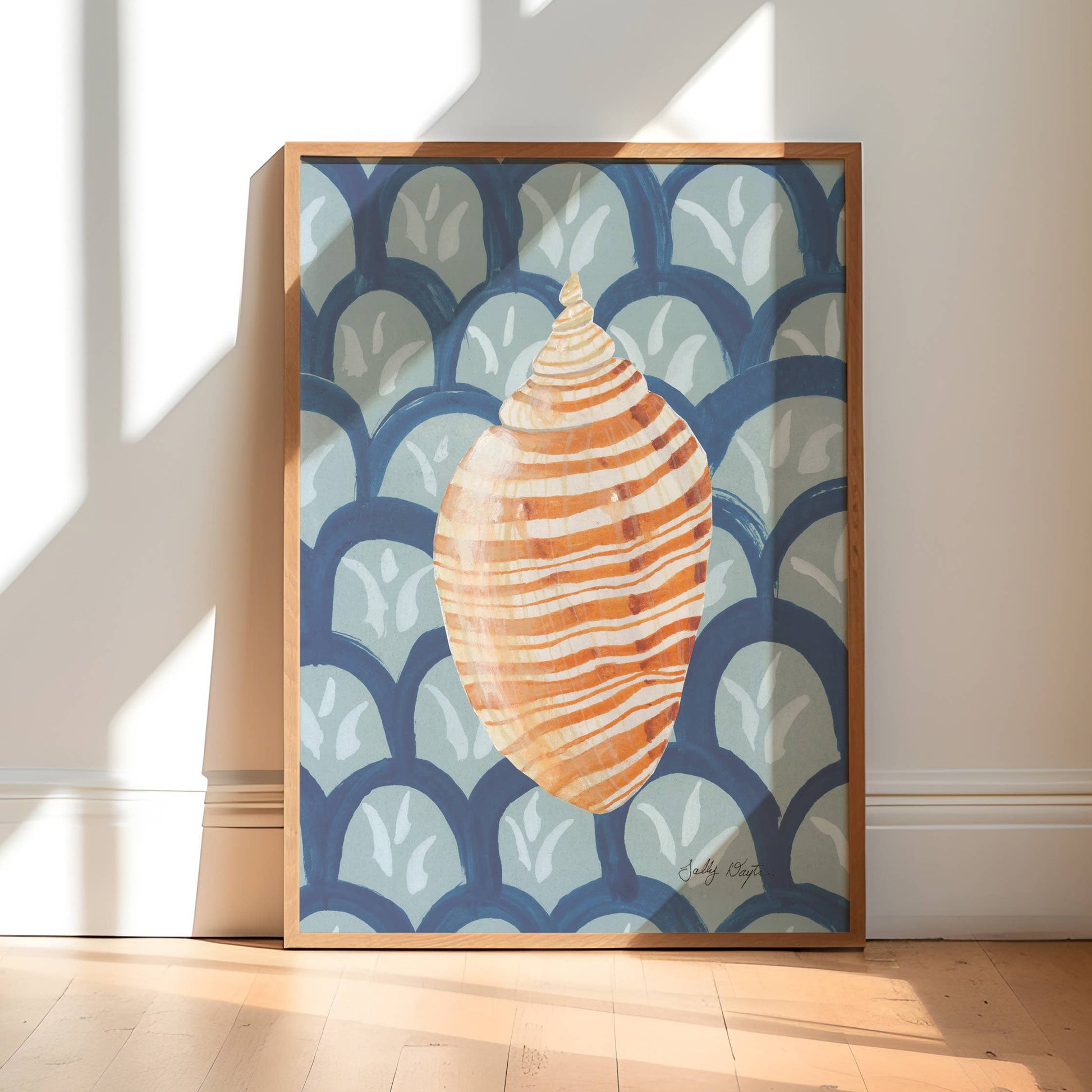 Framed artwork of a shell design on a wall in a bright room with sunlight streaming in.