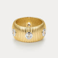 Gold ring with diamond-like stones on a light gray background