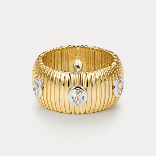 Gold ring with diamond-like stones on a light gray background