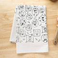 White towel with black cat illustrations on a wooden surface