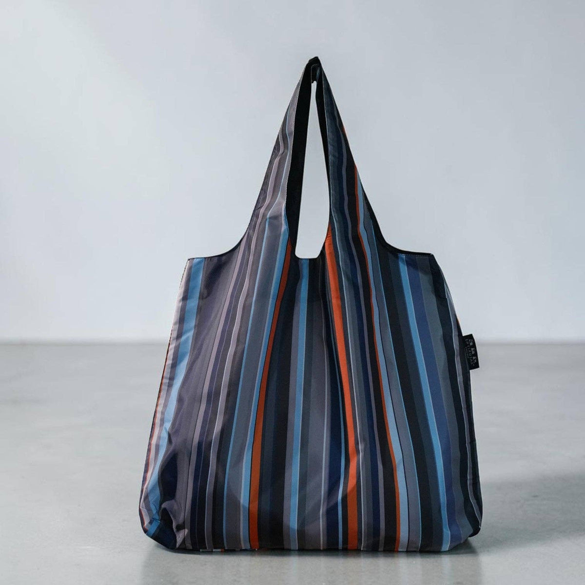 Striped reusable bag on a light gray background