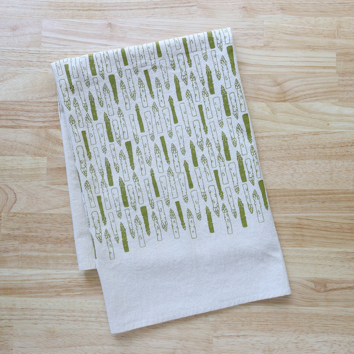 White towel with green pattern on a wooden surface
