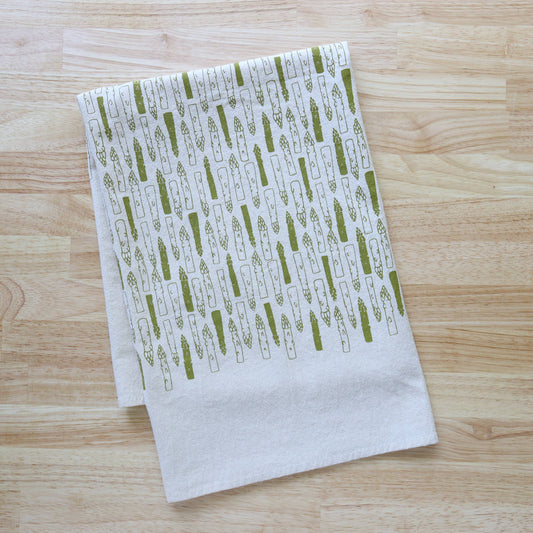 White towel with green pattern on a wooden surface