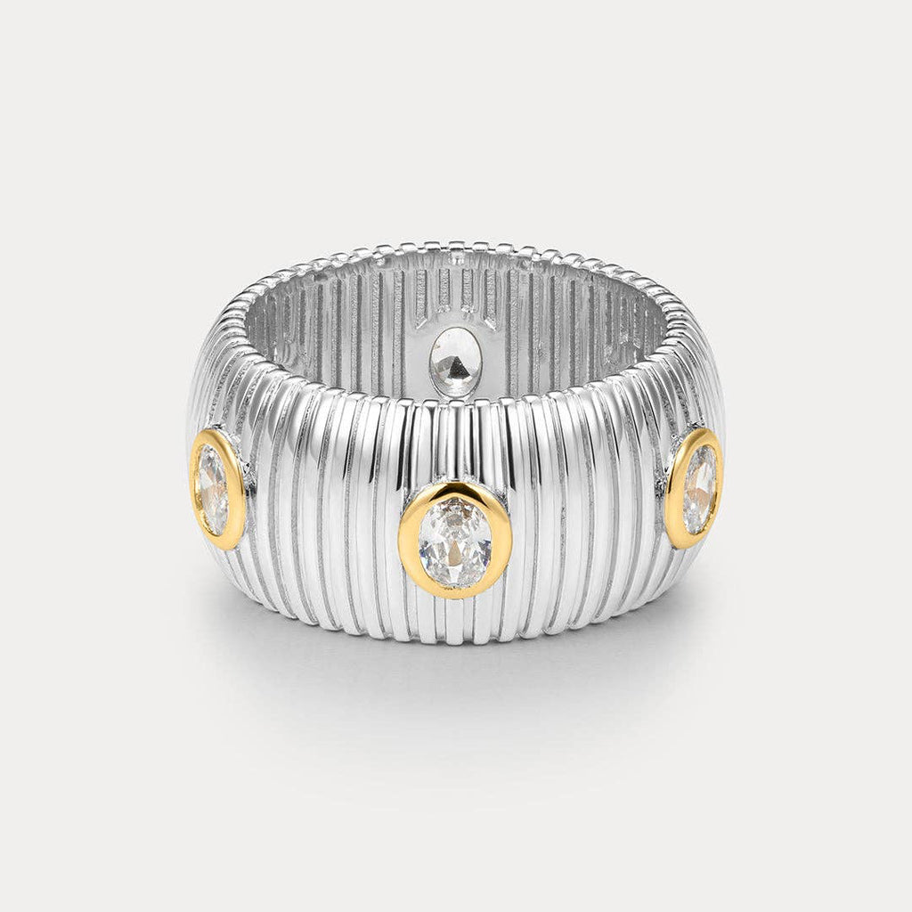 Silver ring with gold accents and embedded diamonds on a light gray background