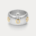 Silver ring with gold accents and embedded diamonds on a light gray background