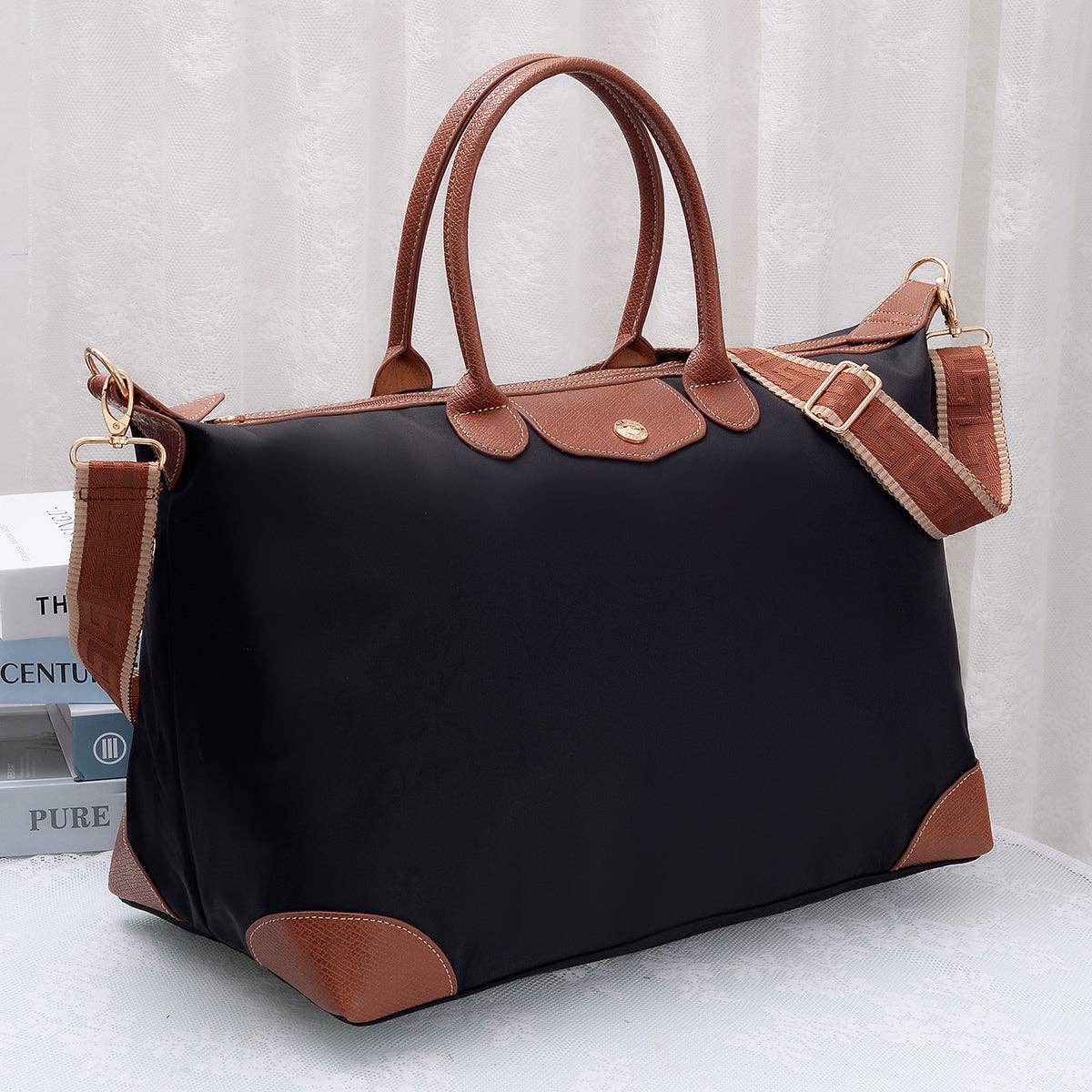 Black handbag with brown handles and trim on a white background