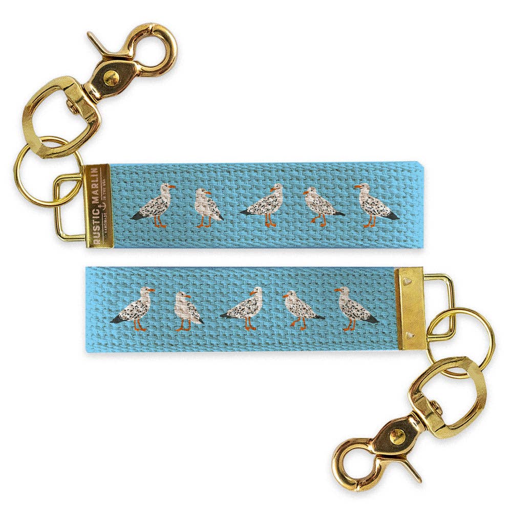 Keychain with seagull pattern on a blue strap against a white background