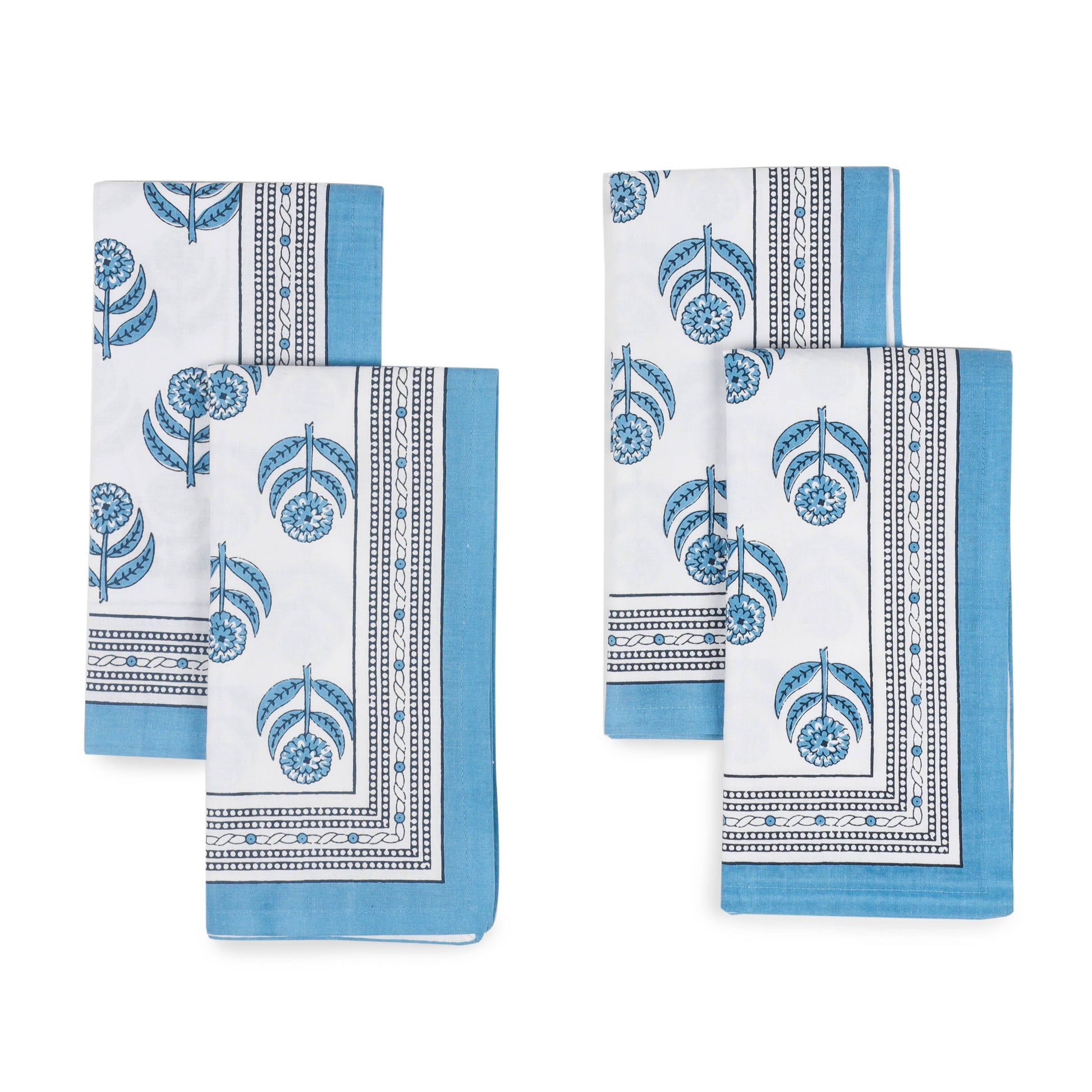 Set of four blue and white patterned napkins on a white background