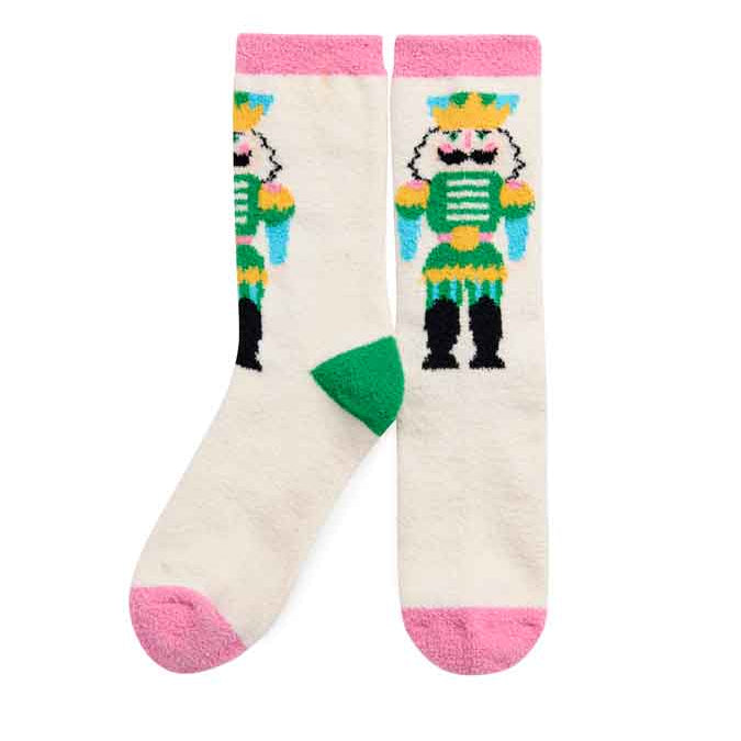 A pair of cream-colored crew socks featuring a colorful pixelated nutcracker graphic and pink toe and cuff accents.