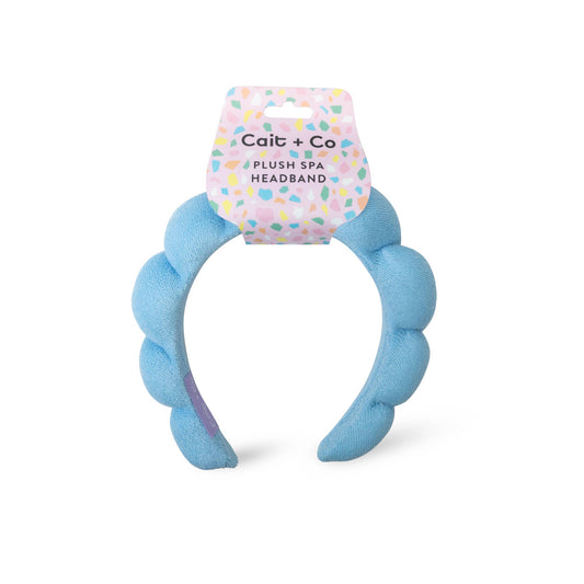 Blue plush headband with packaging labeled 'Cait + Co' on a white background
