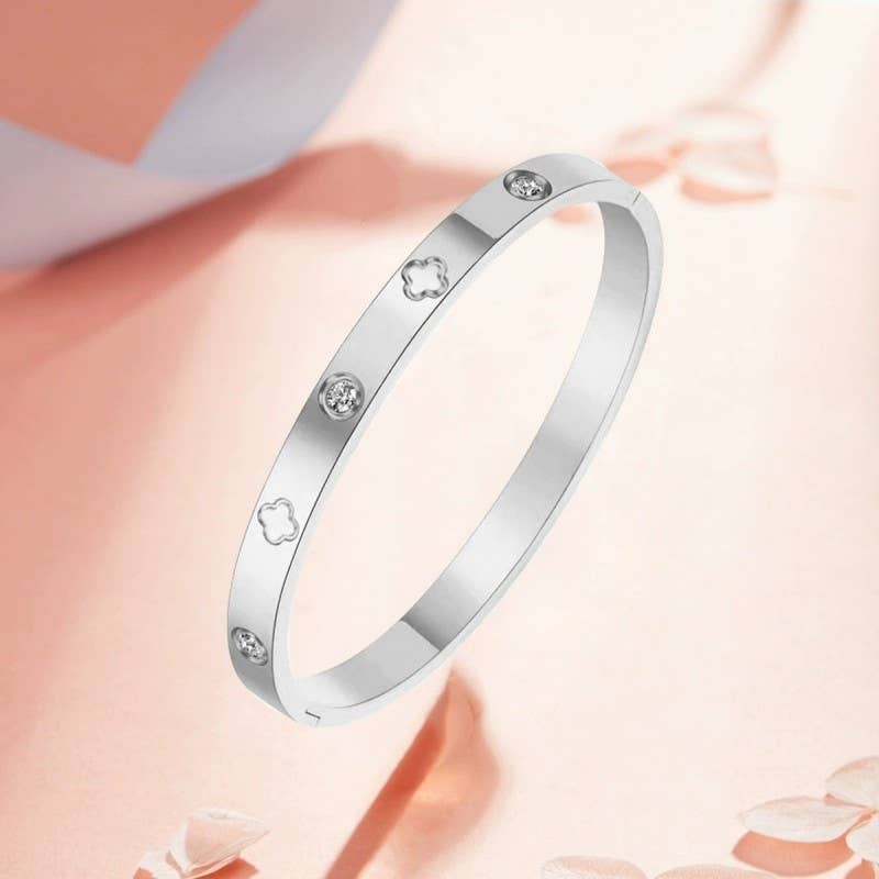 Silver bracelet with diamond accents on a soft pink background